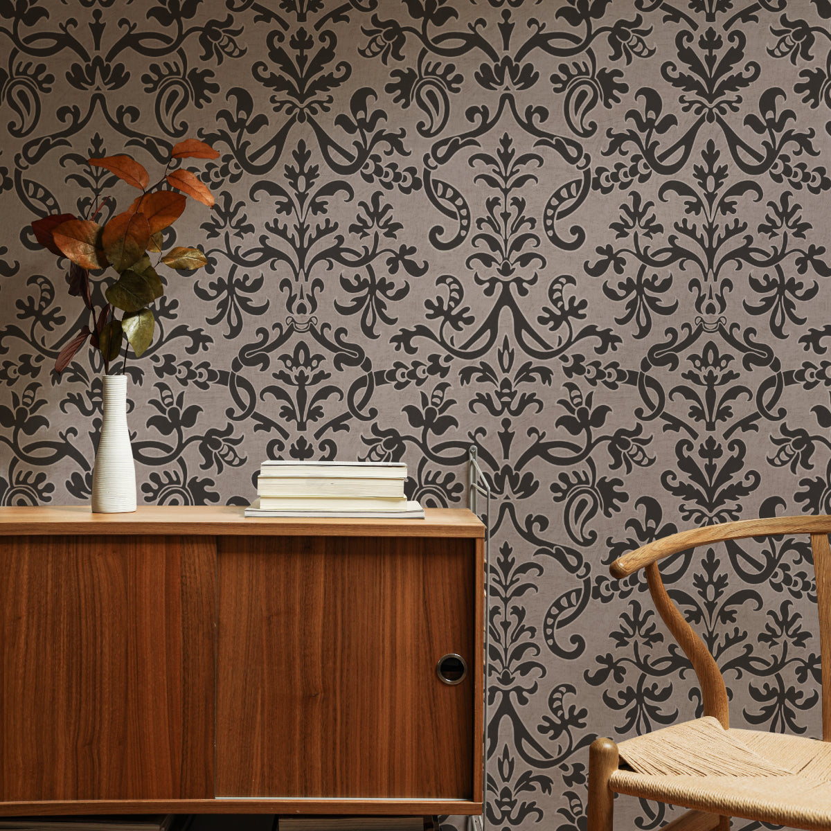 Vintage style study with brown Victorian damask wallpaper, wooden desk, and autumnal decor.