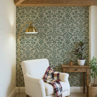 Cozy reading nook with green Victorian damask floral wallpaper, white armchair, and rustic wood accents.