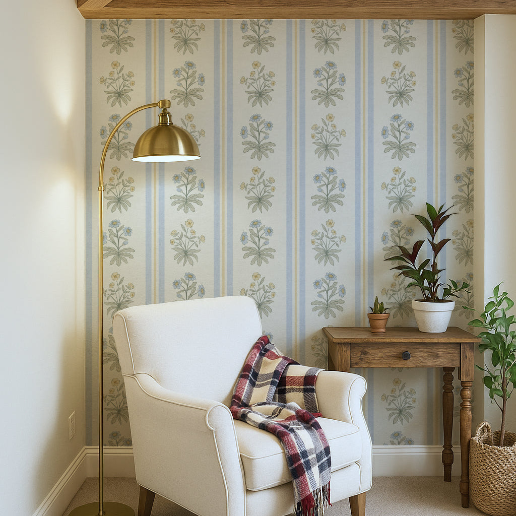 Blue and yellow floral striped wallpaper in a reading nook with a white chair and gold lamp