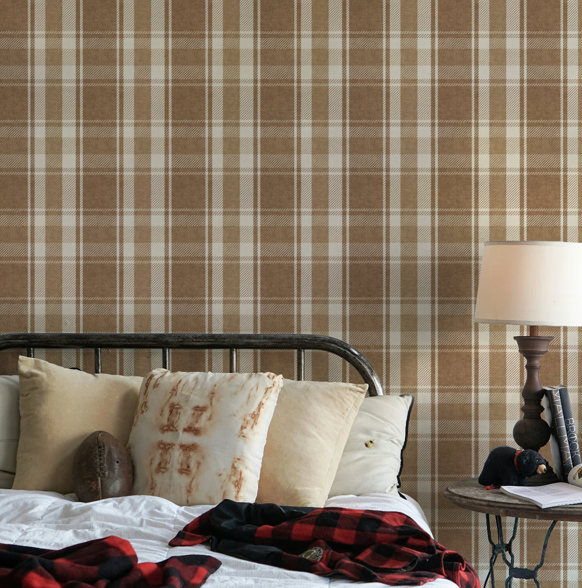 Bedroom with rustic plaid wallpaper in brown and tan behind the bed, layered with neutral bedding and warm accents.