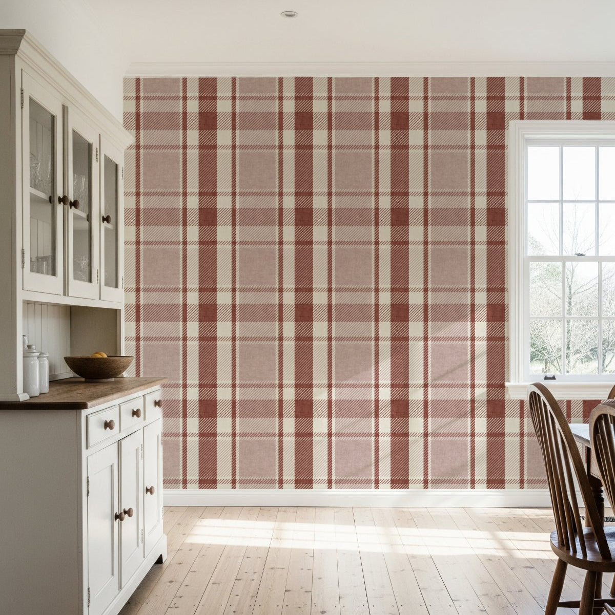 Kitchen or dining space with rustic plaid wallpaper in pink and terracotta, light wood floor and simple white cabinetry.