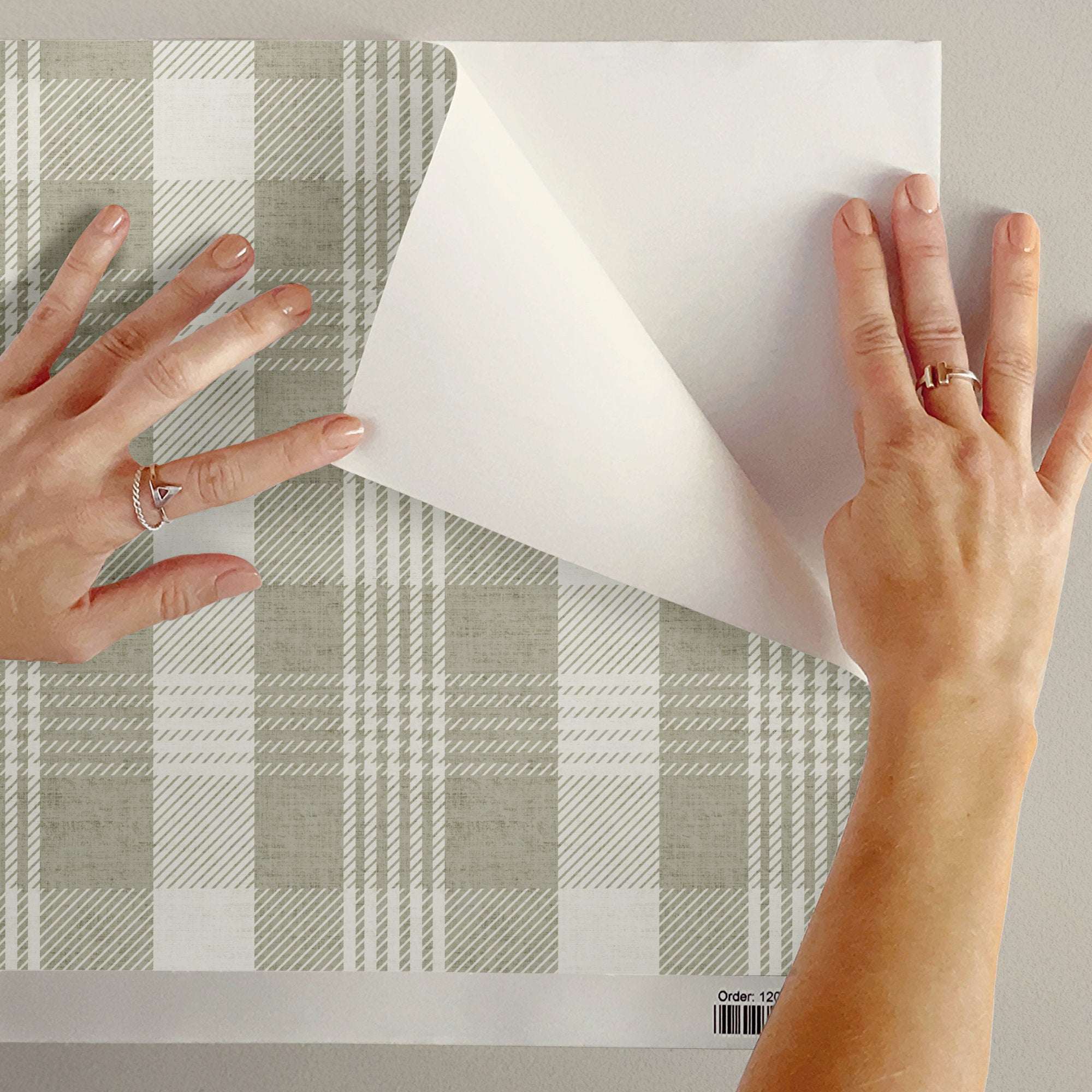 Pastel Plaid wallpaper sheet being applied over soft check tartan in sage and cream